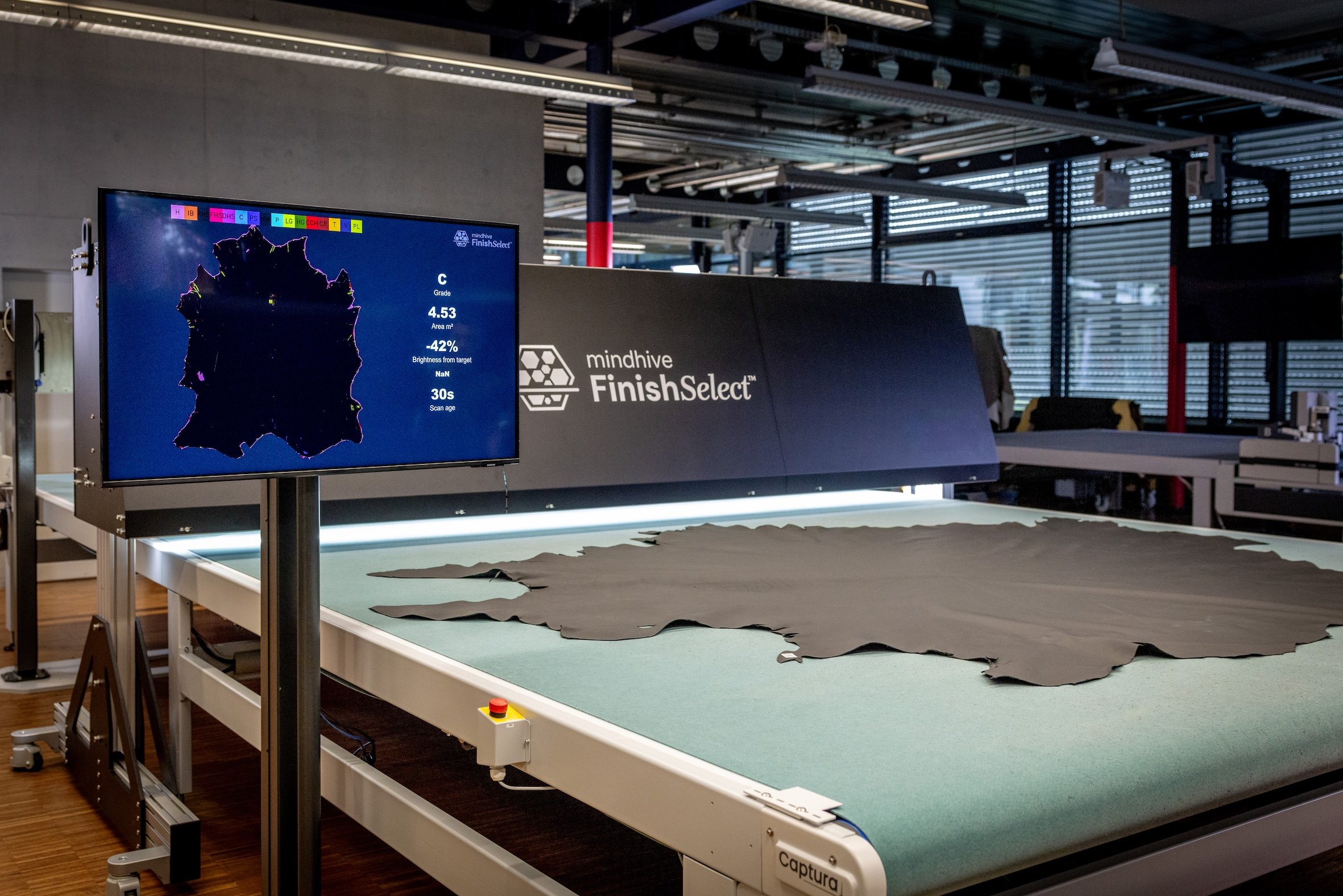 Mindhive FinishSelect™ real-time leather quality analysis and defect mapping, with finished leather hides positioned for automated inspection and grading.
