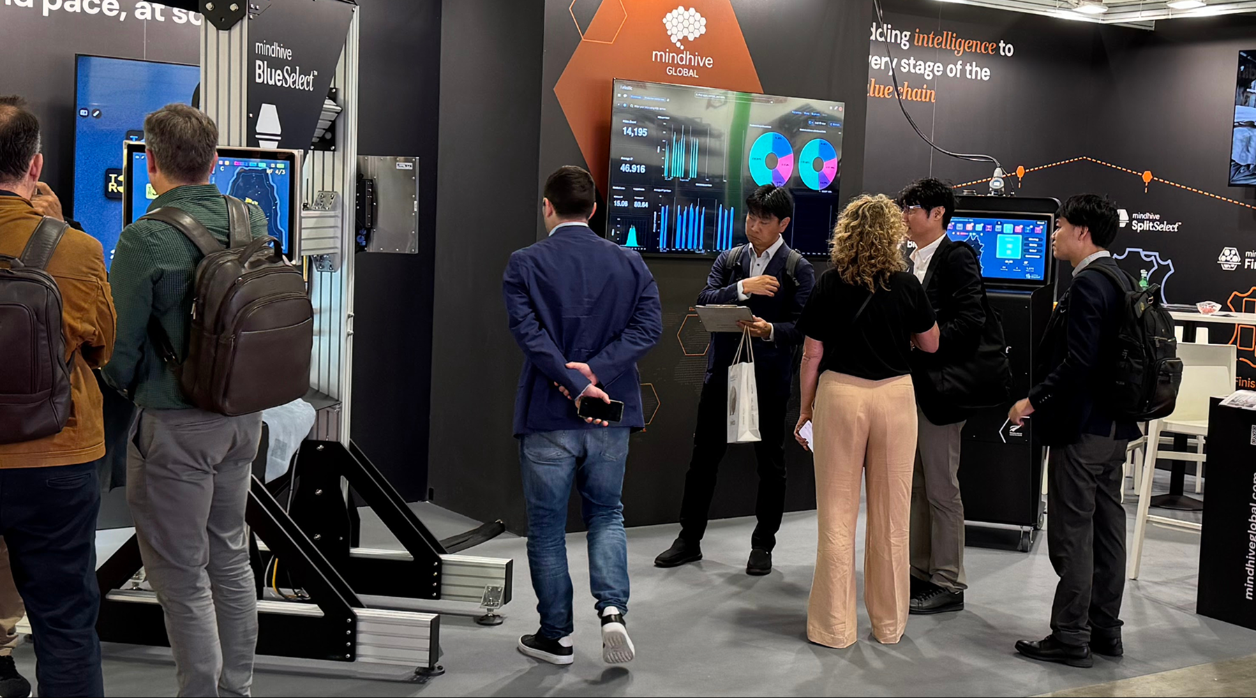 Visitors at Mindhive's SIMAC 2025 booth discussing digital quality intelligence and data integration for leather manufacturing.